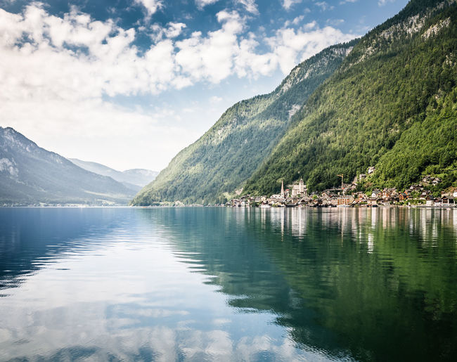 Scenic view of lake by mountains against sky