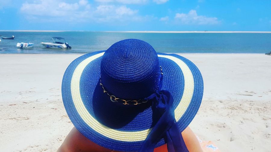 Close-up of hat on beach against sky