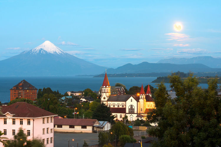 Moon rising on puerto varas at the shores of lake llanquihue with osorno volcano in the back, chile