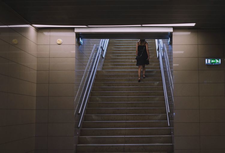 Rear view of woman walking on steps