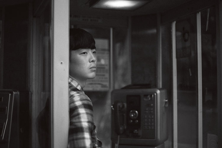 Young man at telephone booth