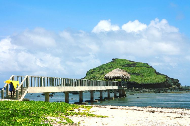 Pier over sea against cloudy sky