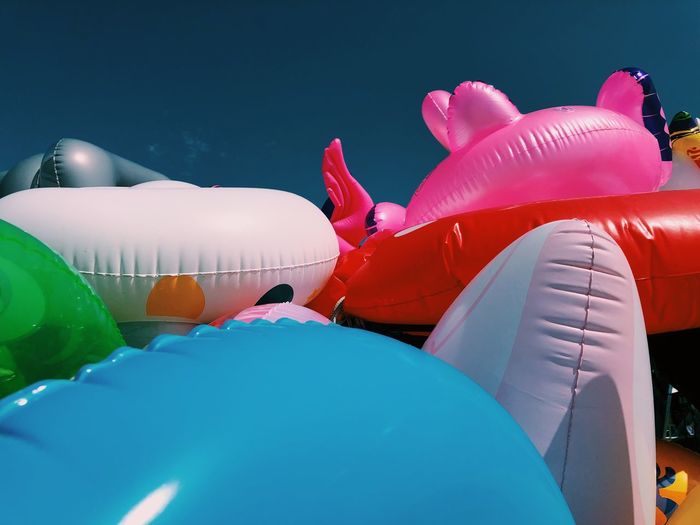Low angle view of multi colored balloons in swimming pool against sky