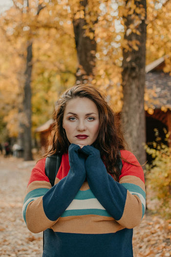 Portrait of beautiful young woman standing in park during autumn