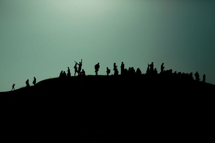 Silhouette people standing against sky