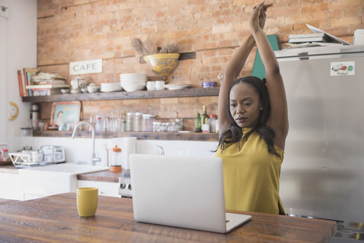 Businesswoman stretching while working at home