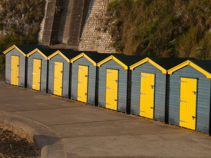 Row of beach huts on road by building