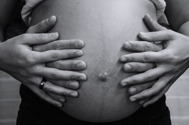 Cropped hands of man touching stomach of pregnant woman