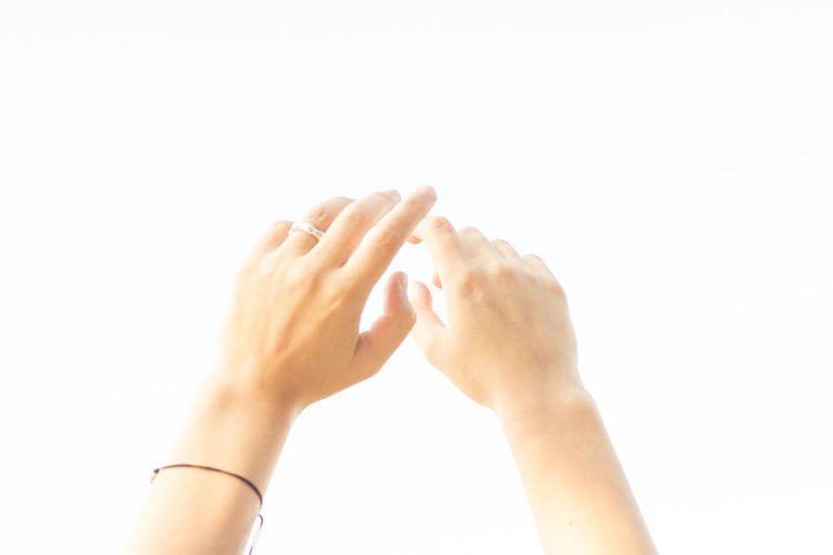 Close-up of hands against white background