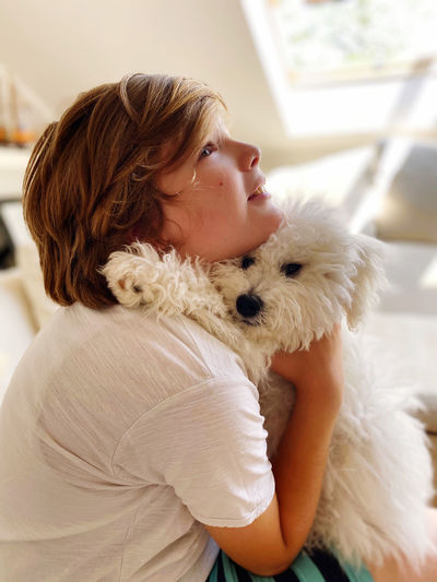 Close-up of boy embracing dog at home