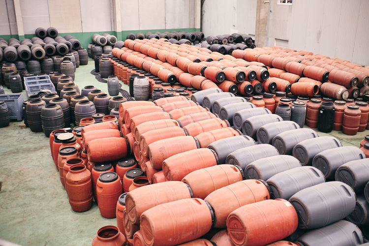 High angle of assorted plastic barrels stored in spacious warehouse in industrial area of factory