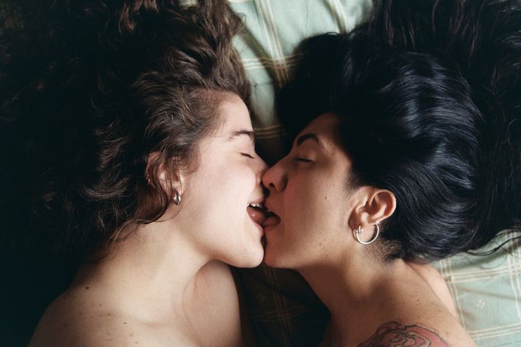 Close-up of lesbian couple kissing on bed