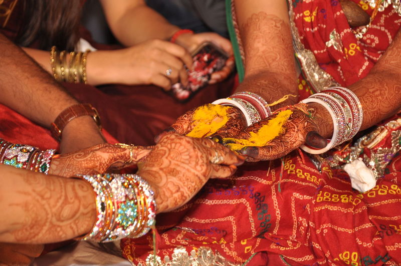 Woman performing rituals on bride during wedding