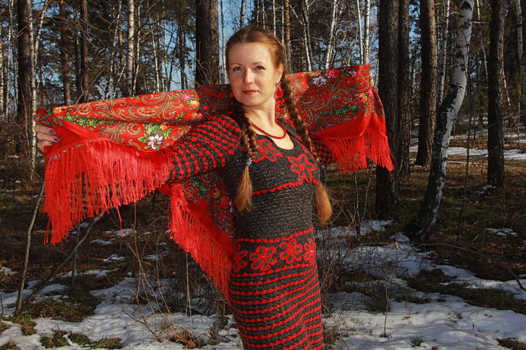 Portrait of woman standing in forest during winter