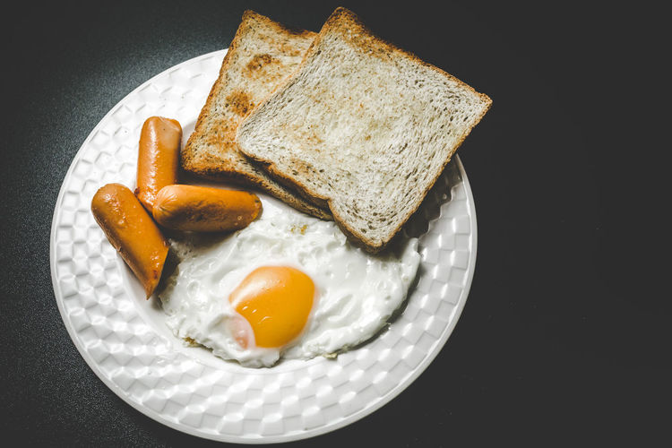High angle view of breakfast served in plate over black background