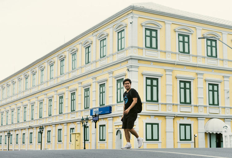Full length of man running against building in city