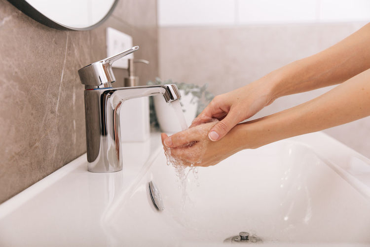 Washing hands under the flowing water tap. hygiene concept hand detail. 