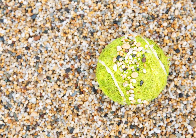 Directly above shot of tennis ball on pebbles