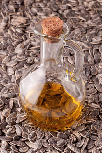 Glass pitcher of sunflower oil on the sunflower seeds