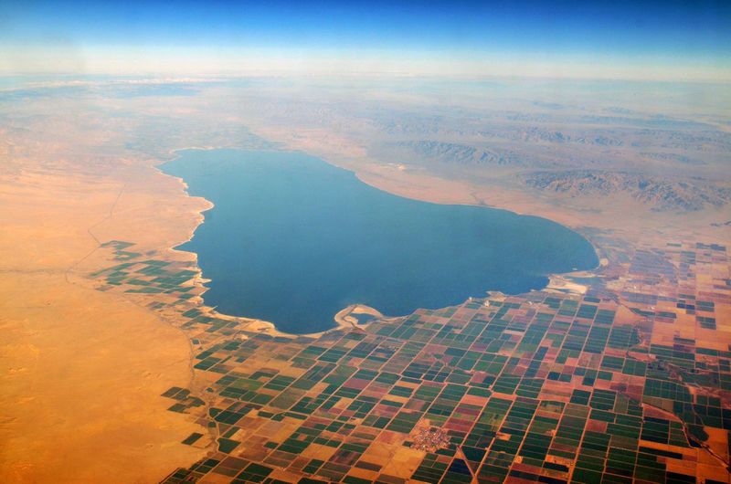 Aerial view of salton sea amidst field against sky