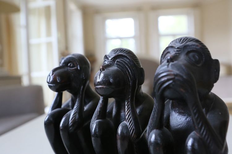 Close-up of three wise monkey statues
