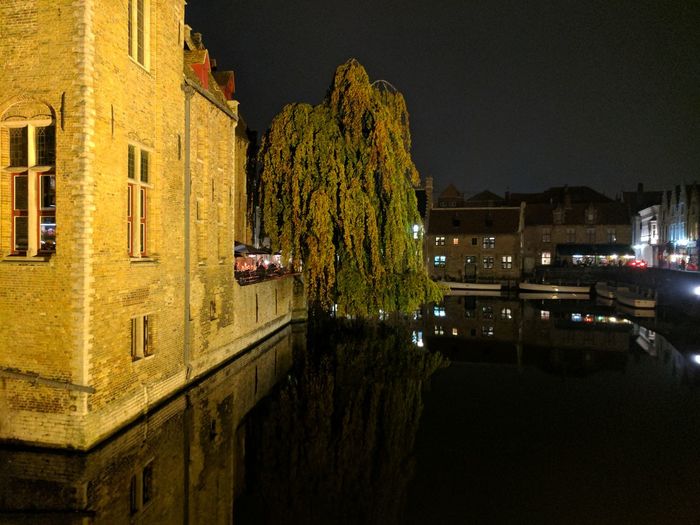 Canal amidst buildings in town against sky at night
