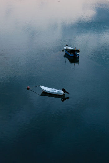 Vertical shot of anchored sailboats on a calm water