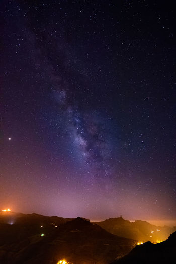 Illuminated mountains against sky at night