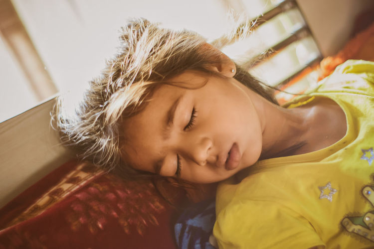 Portrait of cute baby sleeping on bed at home
