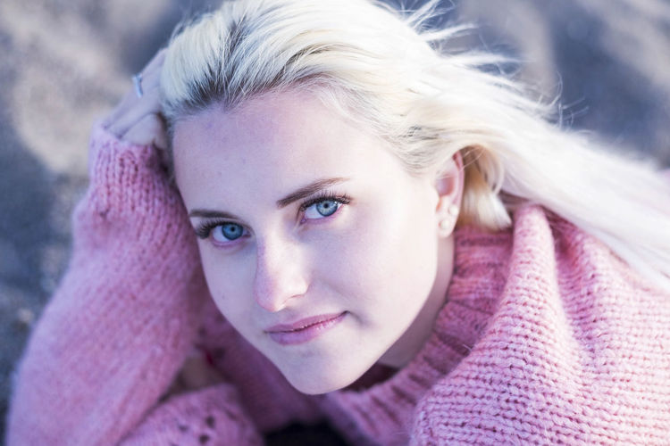 Close-up portrait of woman in pink sweater with blond hair