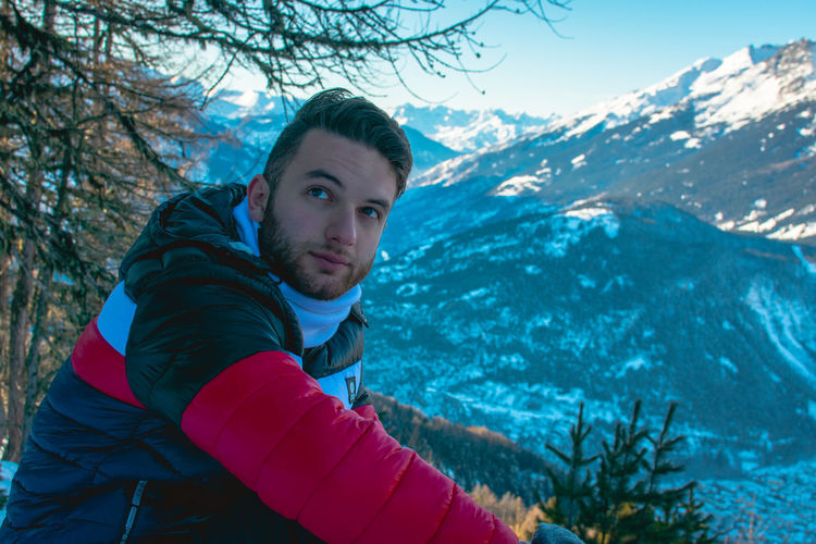 Portrait of young man in snowy mountains 