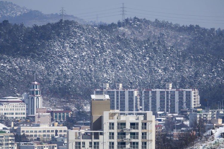 Buildings in city against sky during winter