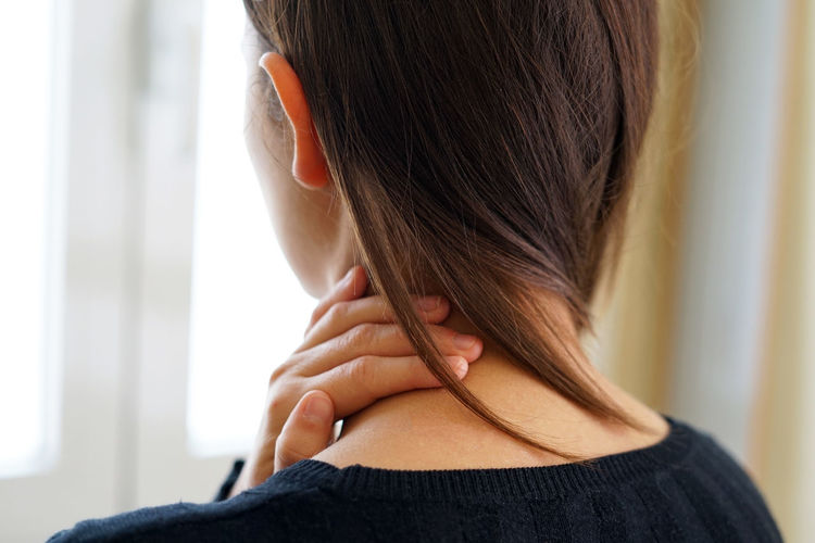 Woman with neck pain touching her neck. neck pain concept.