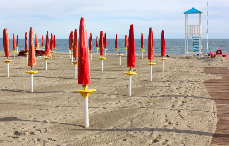 Row of parasols on beach against sky