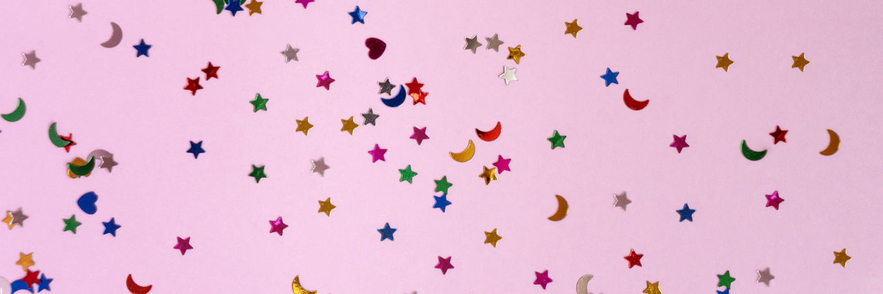 Festive pink background with many colorful stars. christmas, new year, birthday theme concept