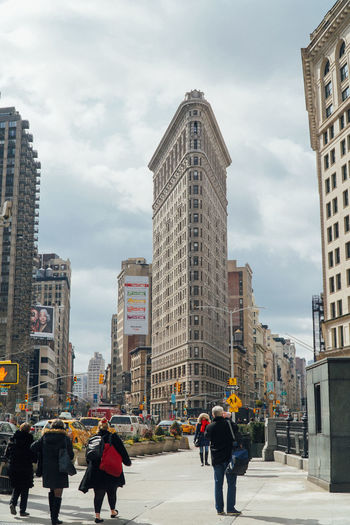 People walking in city against sky new york flatron