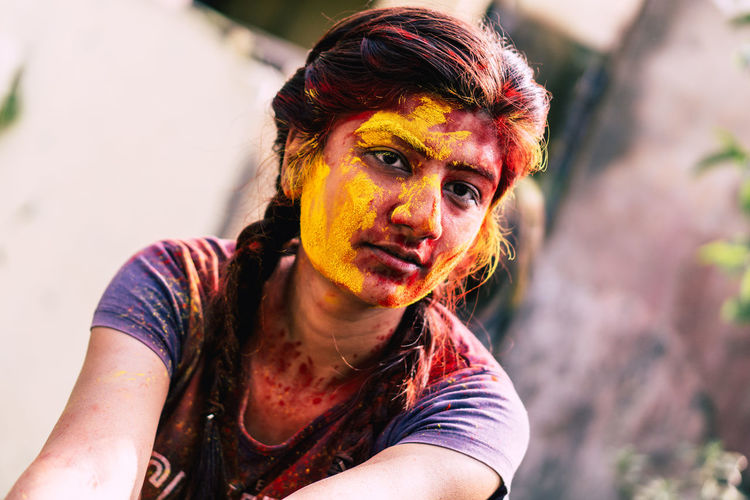 Young woman with powder paint on face during holi
