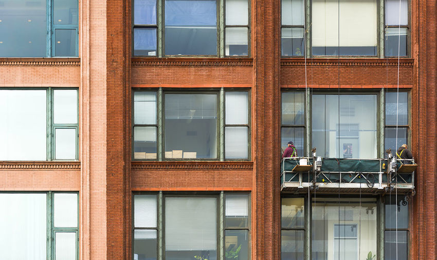 Worker cleaning windows of building