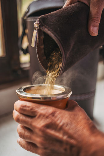 Cropped hand of person pouring coffee on table