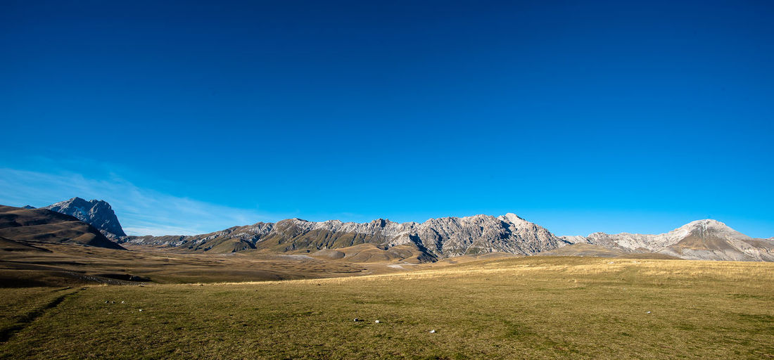 Scenic view of rocky mountains against clear blue sky