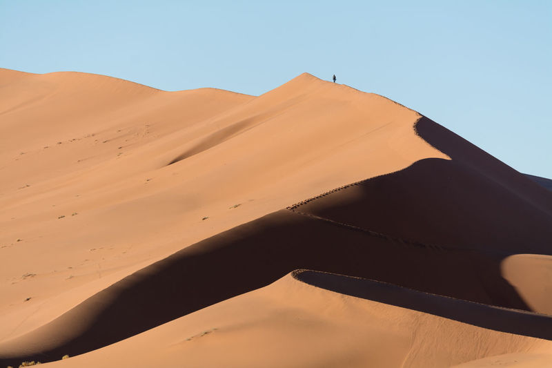 Scenic view of sand dunes at namib-naukluft national park against clear sky