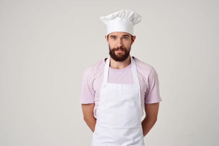 Portrait of chef standing against white background