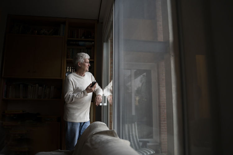 Man standing by window at home