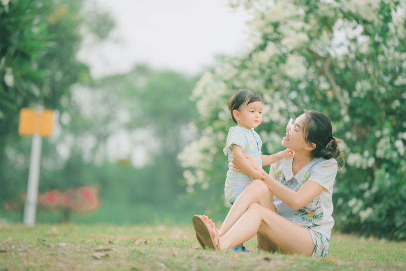 Side view of mother and girl with arms raised