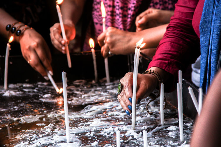 Close-up of hands holding candles
