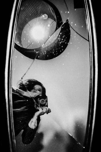 Reflection of woman holding camera in mirror