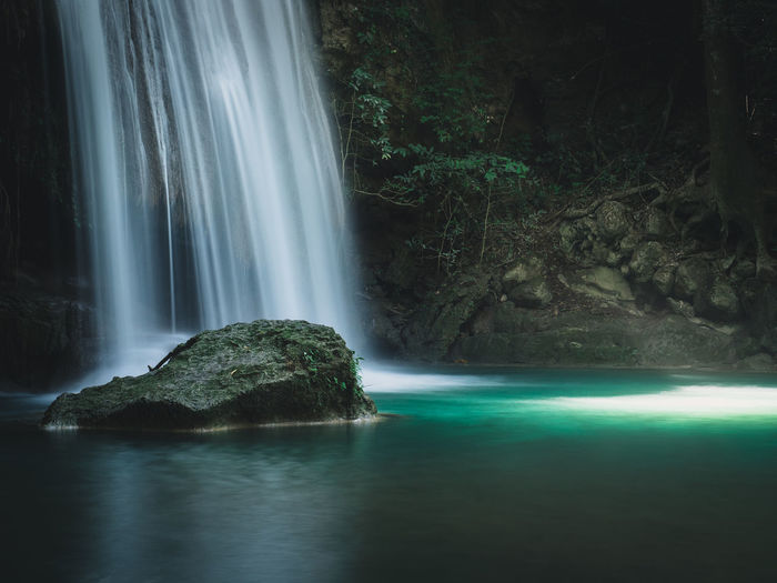 Stunning waterfall smooth stream, sunbeam and turquoise pond. erawan falls, kanchanaburi, thailand.