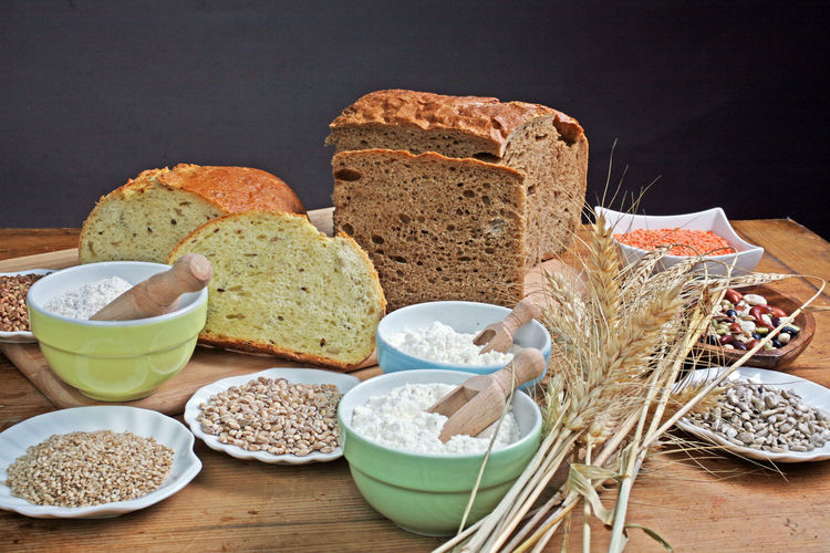 Close-up of homemade bread and necessary ingredients on table