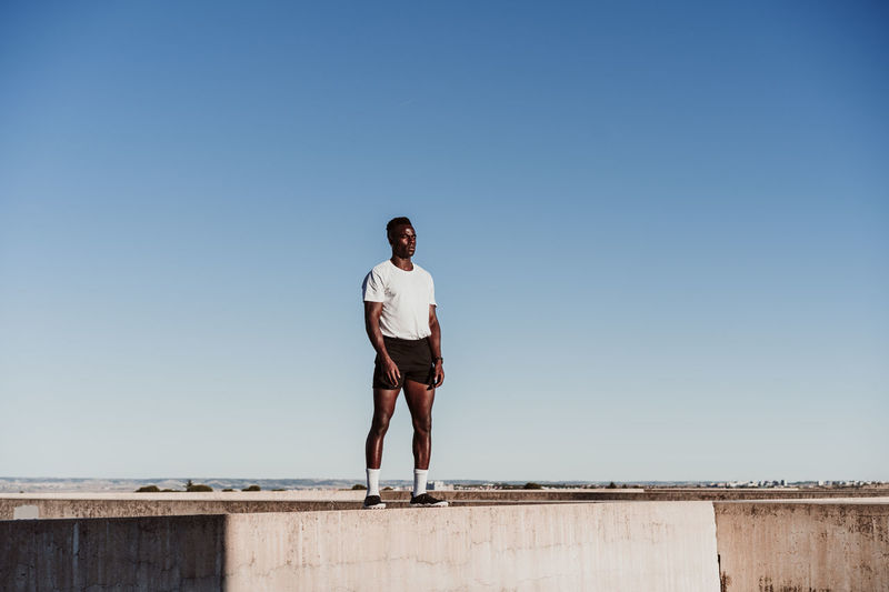 Portrait of young man standing against clear sky