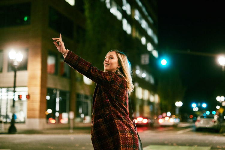 Young woman standing on street at night